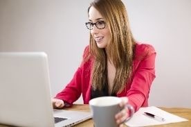 女人在白色笔记本电脑上工作。