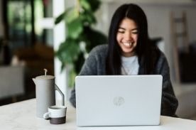 微笑的女孩在笔记本电脑。