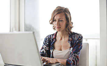 女人在笔记本电脑前工作。